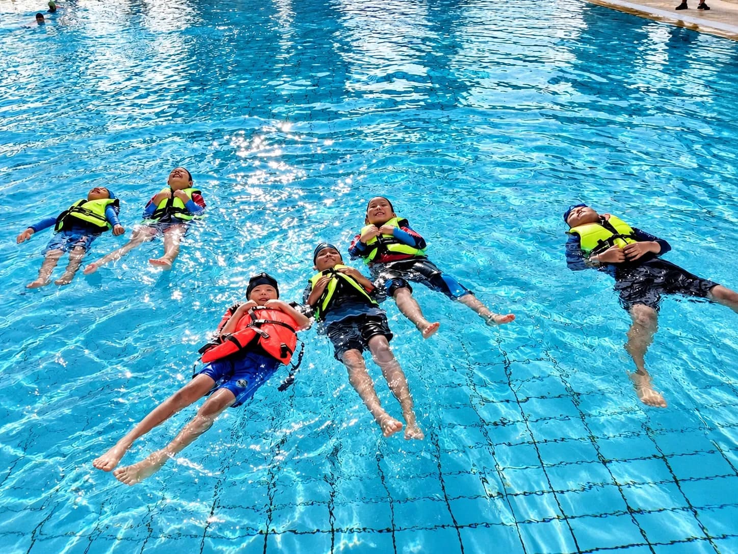 Students in life jackets practising back floating