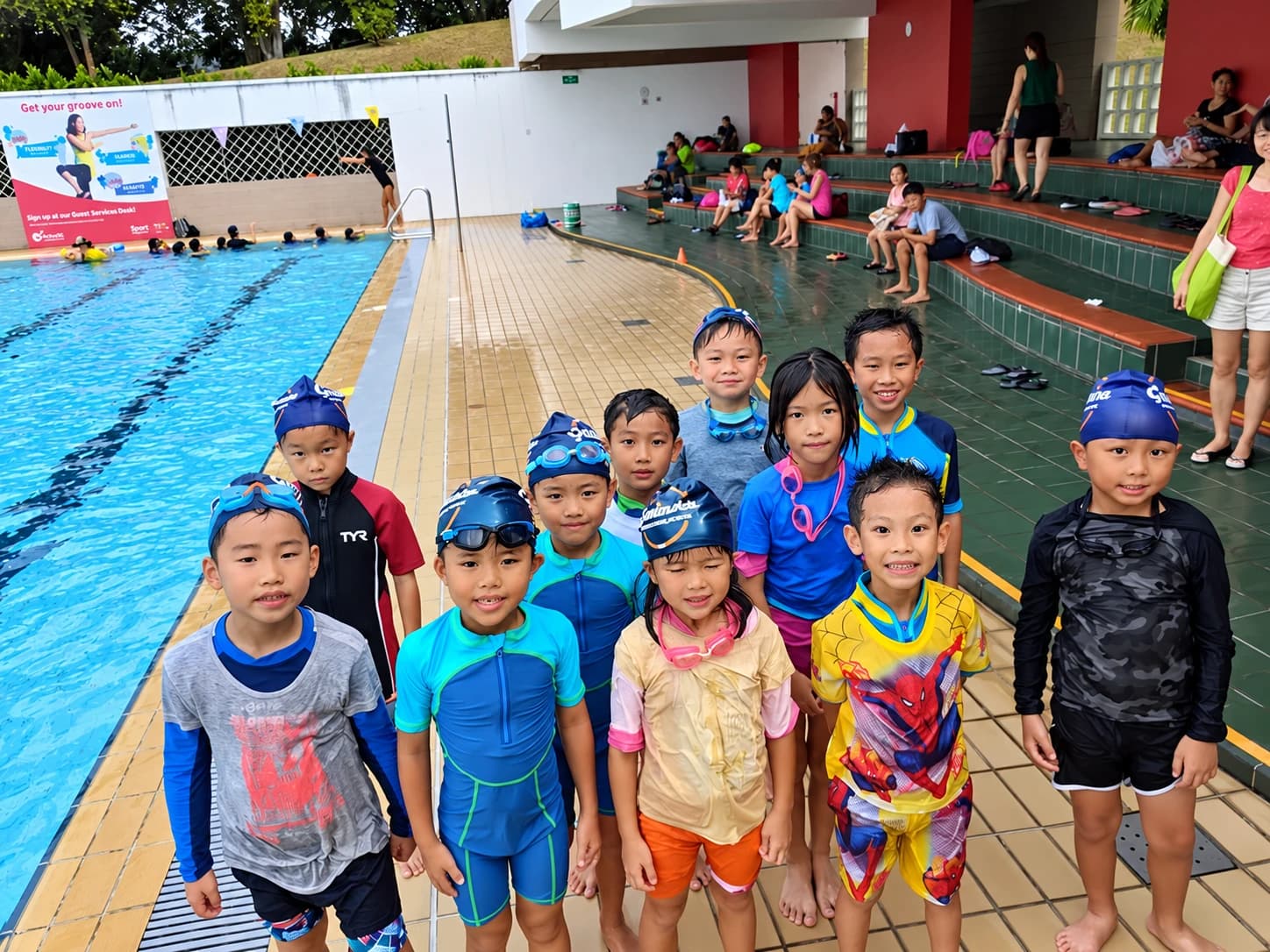 Group of students in Geniusea caps at a public pool