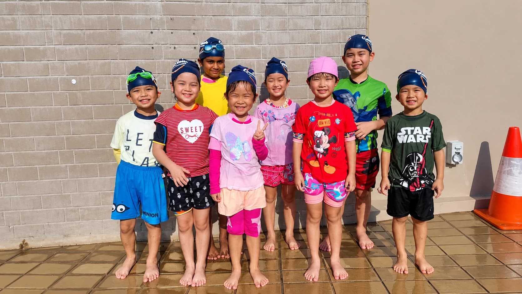 Smiling group of young swimmers in Geniusea caps
